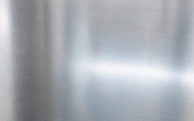 8K mirror-polished stainless steel clad plate surface, macro detail of the specular finish
