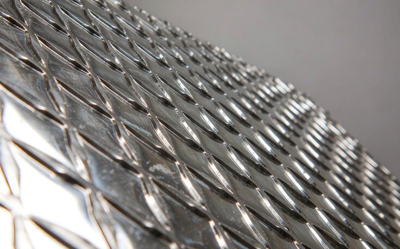 Embossed stainless steel plate with a raised diamond pattern, macro detail